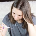 Woman holding thermometer in hands, measuring body temperature. More of my photos and videos Adobe Stock:http://bit.ly/3RqlciK More of my photos and videos Shutterstock: https://www.shutterstock.com/g/ALEKSANDRBERDYUGIN My email: bermix999@gmail.com